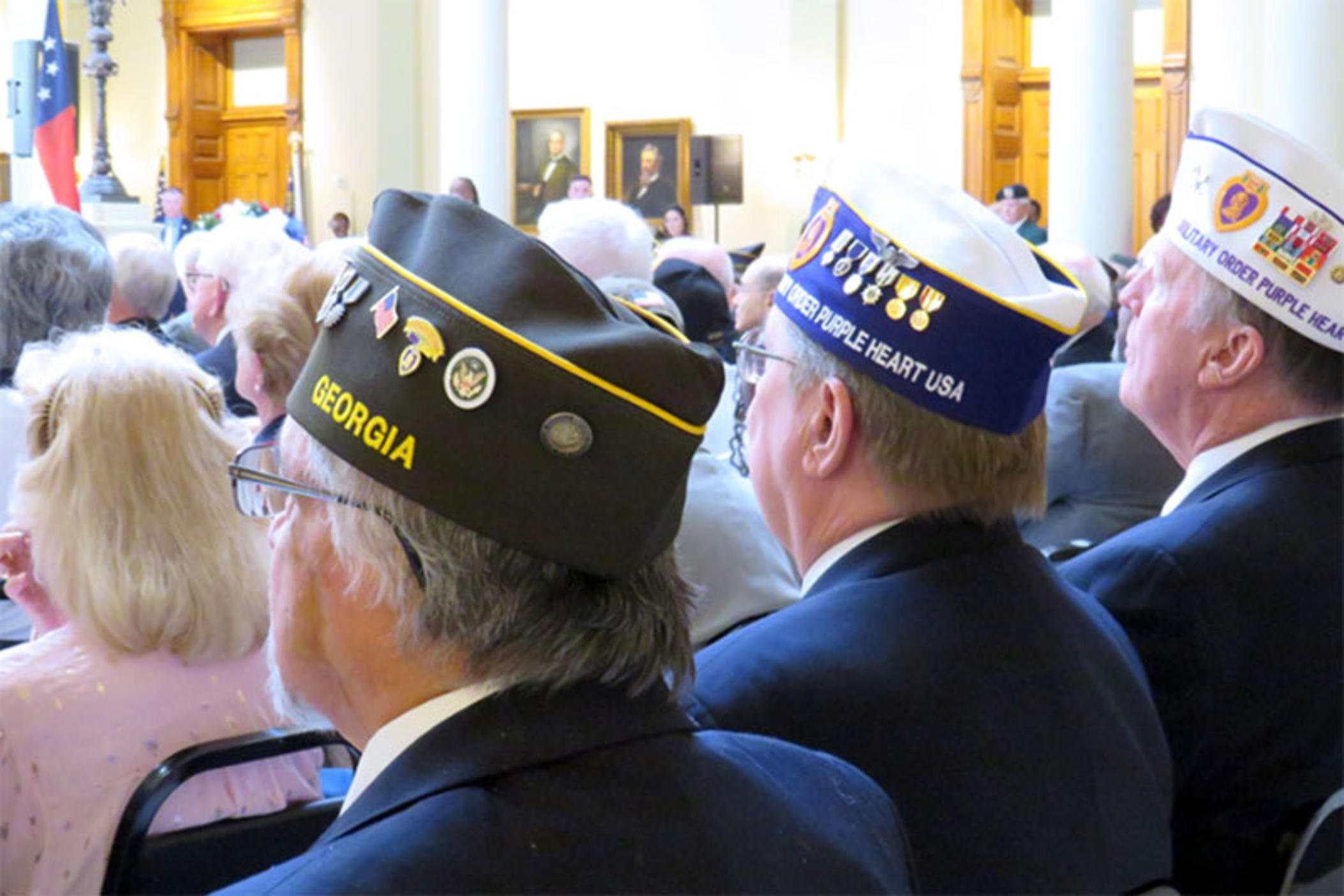 Veteran representatives from the American Legion and Purple Heart observe a Veterans Day celebration at the state capitol.