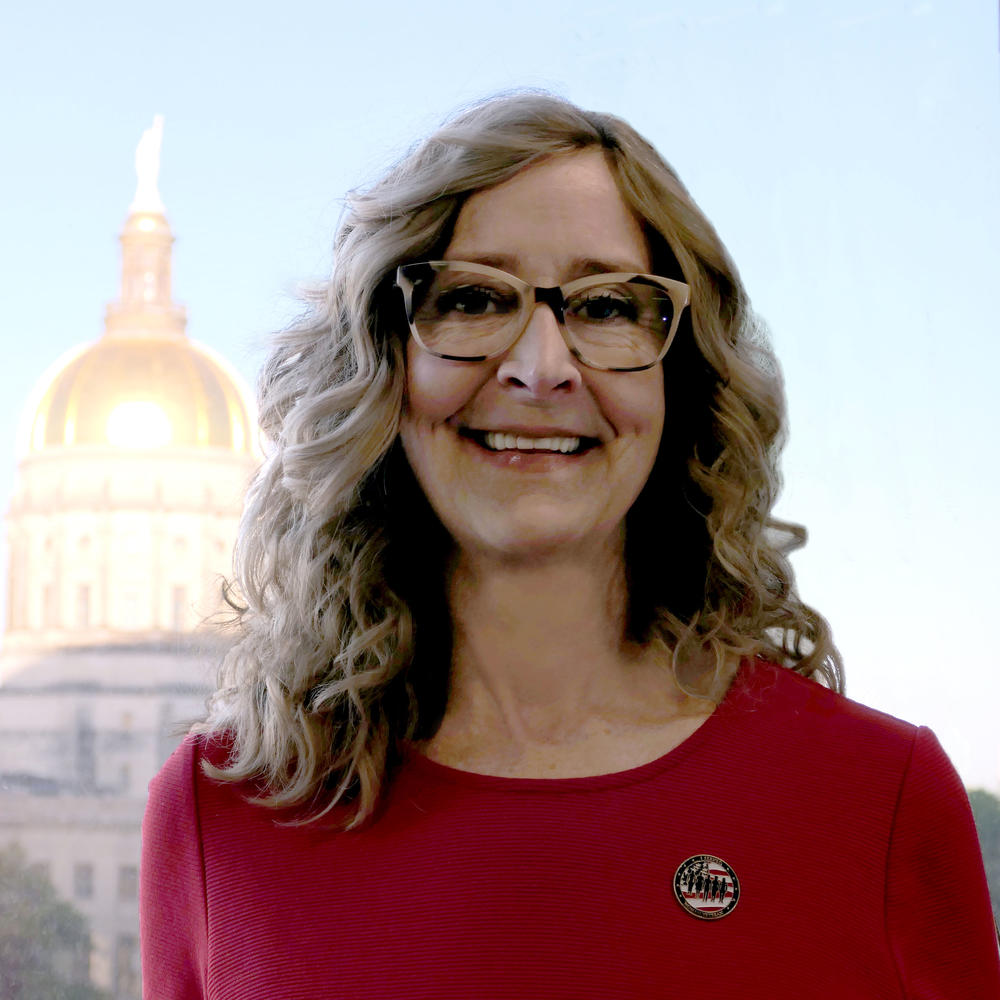 A photo of Commissioner Ross in front of the state capitol building. 